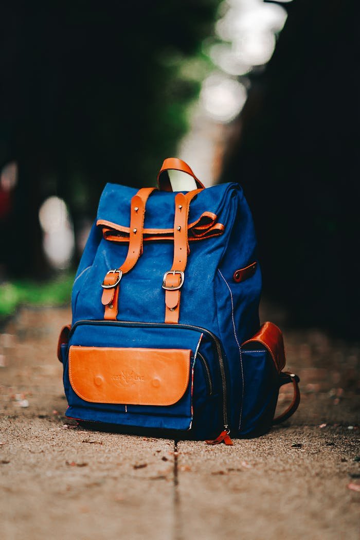 Close-up of a fashionable blue backpack on a city sidewalk in São Paulo.